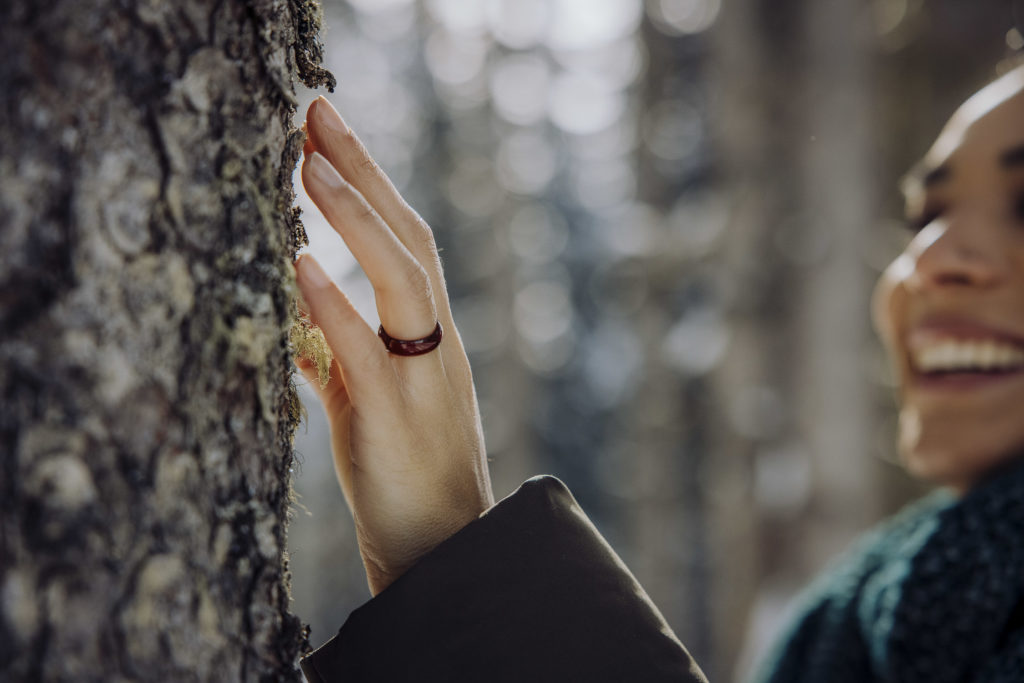 Frau berührt Baumrinde, Altenmarkt-Zauchensee, Salzburg