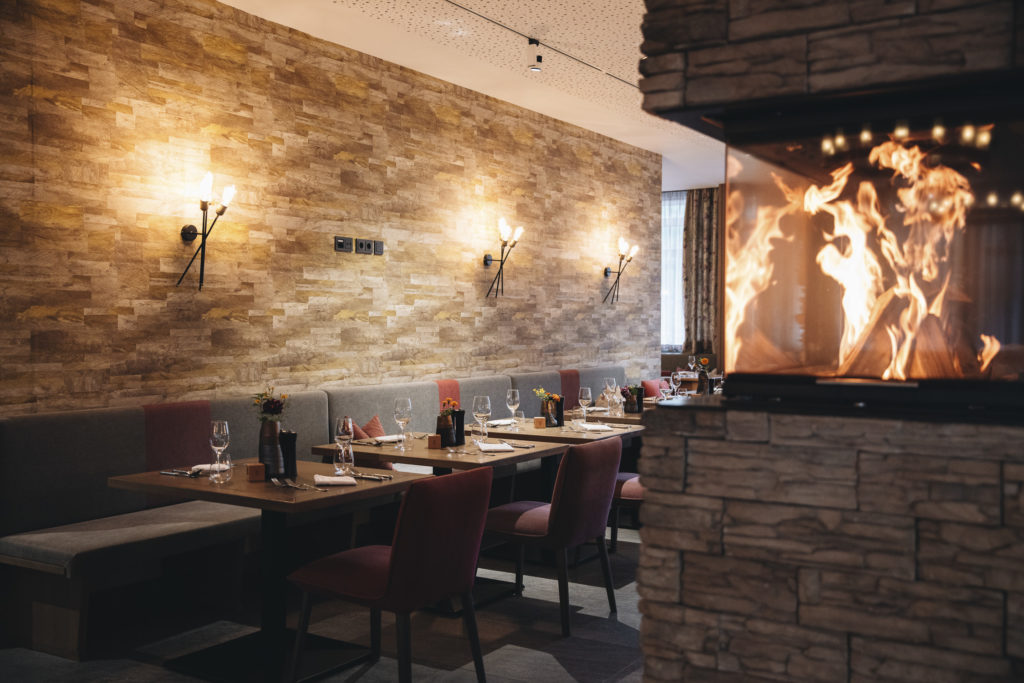 Hotelrestaurant mit Kaminfeuer im Adler Resort, Saalbach-Hinterglemm